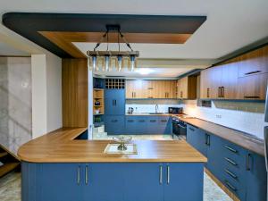 una grande cucina con mobili blu e un'isola di legno di Lisaneli a Mestia