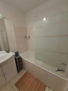 a white bathroom with a tub and a sink at Au feu de Berque in Cherbourg en Cotentin +4 photos