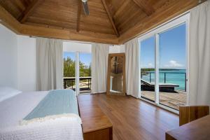 a bedroom with a bed and a view of the ocean at Touch of Class home in Savannah Sound