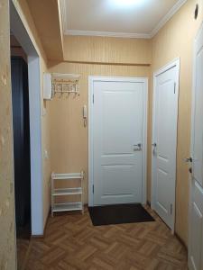 - un couloir avec une porte blanche et du parquet dans l'établissement AURA on Kievskaya, 168, à Bishkek