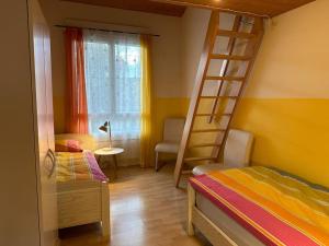 ein Schlafzimmer mit einem Etagenbett und einer Leiter in der Unterkunft Hadassa Apartment Maranatha / Selah in Steffisburg