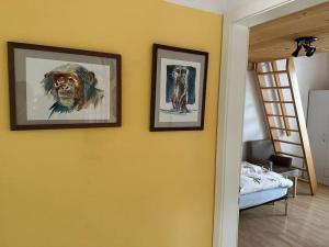 zwei gerahmte Bilder an einer gelben Wand in einem Schlafzimmer in der Unterkunft Hadassa Apartment Maranatha / Selah in Steffisburg