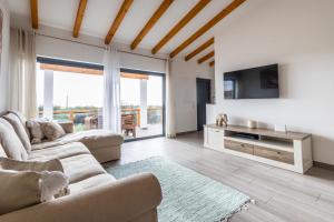 a living room with two couches and a television at Casa Monte Salema in Vila do Bispo