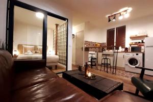 salon ze skórzaną kanapą i kuchnią w obiekcie Midnight in Paris Montmartre w Paryżu