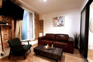 uma sala de estar com um sofá de couro e uma mesa em Midnight in Paris Montmartre em Paris