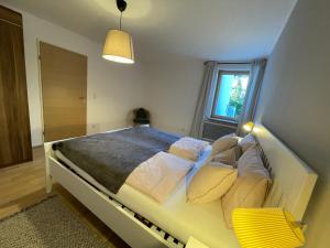 a bedroom with a large bed with a yellow bench at Mi's Apartment in Matrei am Brenner