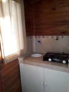 cocina con encimera y fregadero en cabañas del bosque en Pinamar