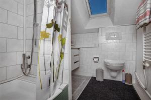 een witte badkamer met een douche en een toilet bij Hadassa Apartments Navah in Uetendorf