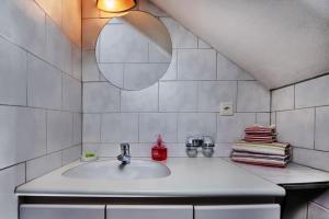 Baño blanco con lavabo y espejo en Hadassa Apartments Navah, en Uetendorf