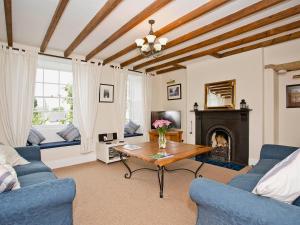 a living room with a table and a fireplace at Cherry Tree Cottage in Bellerby