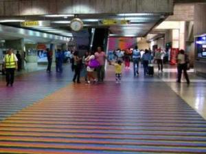 a group of people walking in an airport terminal at Airport BleuSuite Apartment in Catia La Mar