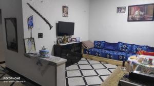 a living room with a blue couch and a tv at Villa familys in Fez