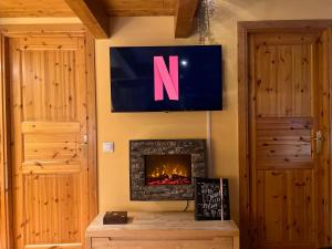 a living room with a tv and a fireplace at AndBnB I Duplex Rustico en Plena Naturaleza I Parking Gratis in Canillo