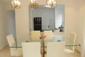 comedor con mesa de cristal y sillas blancas en Exclusive Luxury Modern Home near Robinson's Place, en Manila