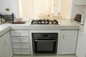 cocina con fogones y encimera blanca en Exclusive Luxury Modern Home near Robinson's Place, en Manila