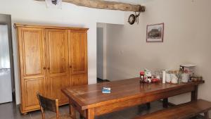 a kitchen with a wooden table and a wooden cabinet at La Grange Saint-Jacques in Bach