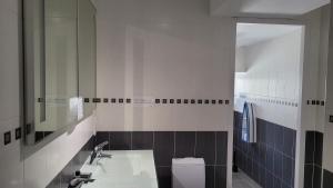 a bathroom with a sink and a mirror and a toilet at La Grange Saint-Jacques in Bach