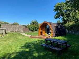 BoncathGarden Cottage Glamping Pod的草木小屋,设有野餐桌