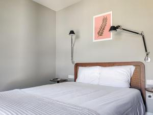 een slaapkamer met een bed met witte lakens en een lamp bij Quinta Dona Iria in Miranda do Corvo