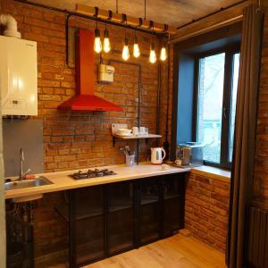 Una cocina con encimera y pared de ladrillo. en Loft city center, en Poltava
