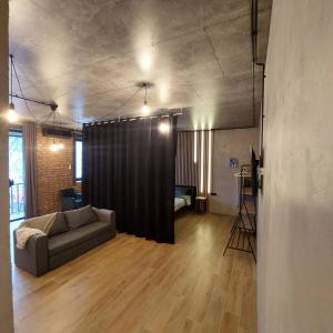 波爾塔瓦的住宿－Loft city center，带沙发和黑色窗帘的客厅