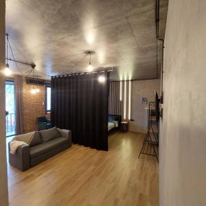 uma sala de estar com um sofá e uma cortina preta em Loft city center em Poltava