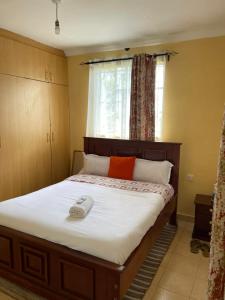 una camera da letto con un letto e un telefono sopra di Zoe Homes 1br and 2br Cottage own compound -Kericho town near Green Square mall a Kericho