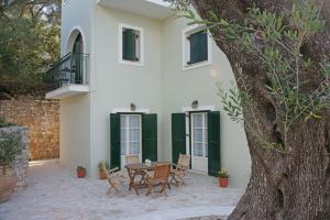 een patio met een tafel en stoelen voor een huis bij Fereniki's place in Gaios