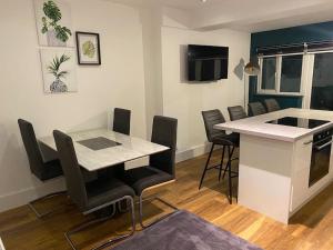 a room with a table and chairs and a kitchen at Cheerful 2 bedroom holiday home with parking in Cleethorpes