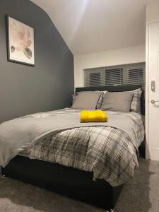 a bedroom with a bed with a yellow blanket on it at Cheerful 2 bedroom holiday home with parking in Cleethorpes