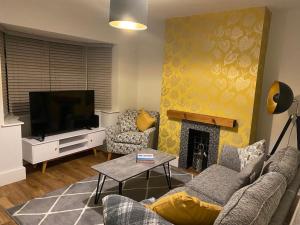 a living room with a couch and a tv at Cheerful 2 bedroom holiday home with parking in Cleethorpes
