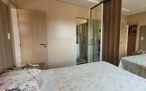 a bedroom with two beds and a walk in shower at Apartamento no centro de Santarém-PA in Santarém