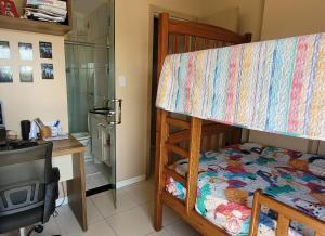 a bedroom with a bunk bed with a desk and a desk at Apartamento no centro de Santarém-PA in Santarém