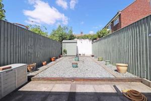 a backyard with a fence and a lot of pots at Cheerful 2 bedroom holiday home with parking in Cleethorpes