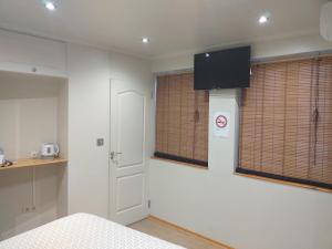 1 dormitorio con 1 cama y TV en la pared en Malaga Ensuites City Centre, en Málaga