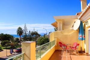 a balcony with chairs and a table on a building at HOSTAL LA ESTACION in Benajarafe