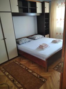 um pequeno quarto com uma cama com lençóis brancos em Apartment Marjana em Podgora