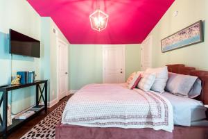 a bedroom with a bed with a pink ceiling at Juleps And Lilies Germantown 1 Bedroom Apartment in Louisville