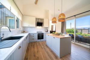 a kitchen with white cabinets and a large window at Jaden Farm House in Fethiye
