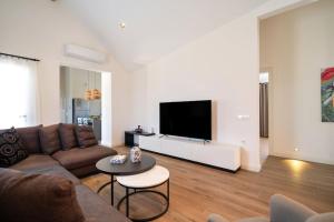 a living room with a couch and a flat screen tv at Jaden Farm House in Fethiye
