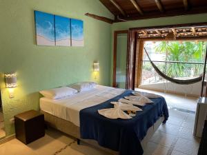 a bedroom with a bed with towels on it at Lalabella Itaguá in Ubatuba