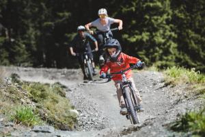 eine Gruppe von Menschen, die auf einer unbefestigten Straße Fahrrad fahren in der Unterkunft Haus Kohlbründl in Saalbach-Hinterglemm