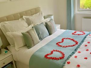 a bed with two red roses on it at Ranmore Rise Retreat in the Surrey Hills in Dorking