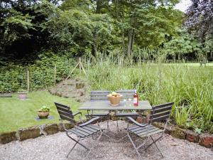 a picnic table with four chairs in a garden at The Low Lodge in Hunmanby