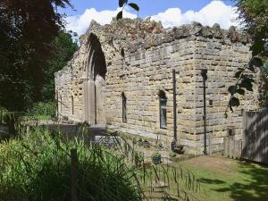 an old stone building with a window in a yard at The Low Lodge in Hunmanby