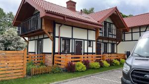 a house with a wooden fence in front of it at Słoneczne Dęby in Dębina