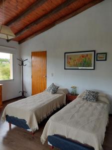 1 dormitorio con 2 camas y ventana en Sol Mayor en Villa Yacanto