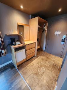 a small kitchen with a counter and a refrigerator at Hôtel le 625 in La Malbaie