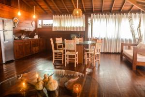 Local Brasil House في مورو دي ساو باولو: مطبخ وغرفة معيشة مع طاولة وكراسي