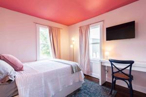 a bedroom with a bed and a chair and a window at Blush And Bashful Germantown Two Bedroom Apartment in Louisville